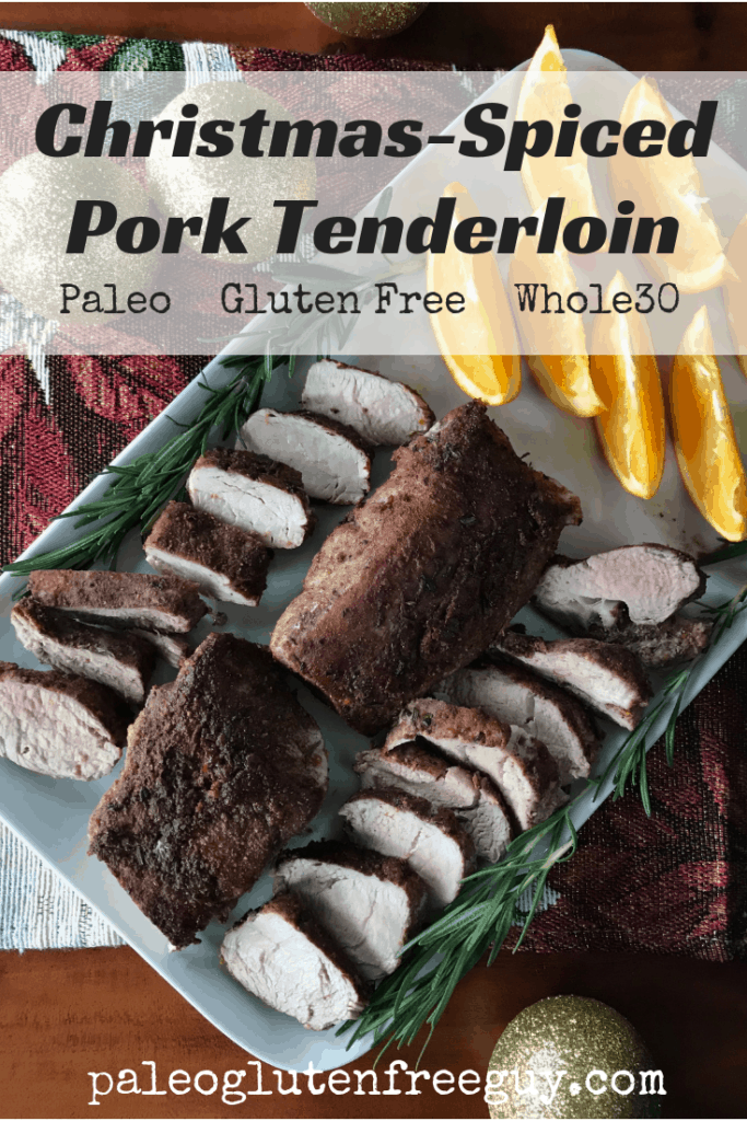 Christmas-Spiced Pork Tenderloin on a white platter surrounded by ornaments