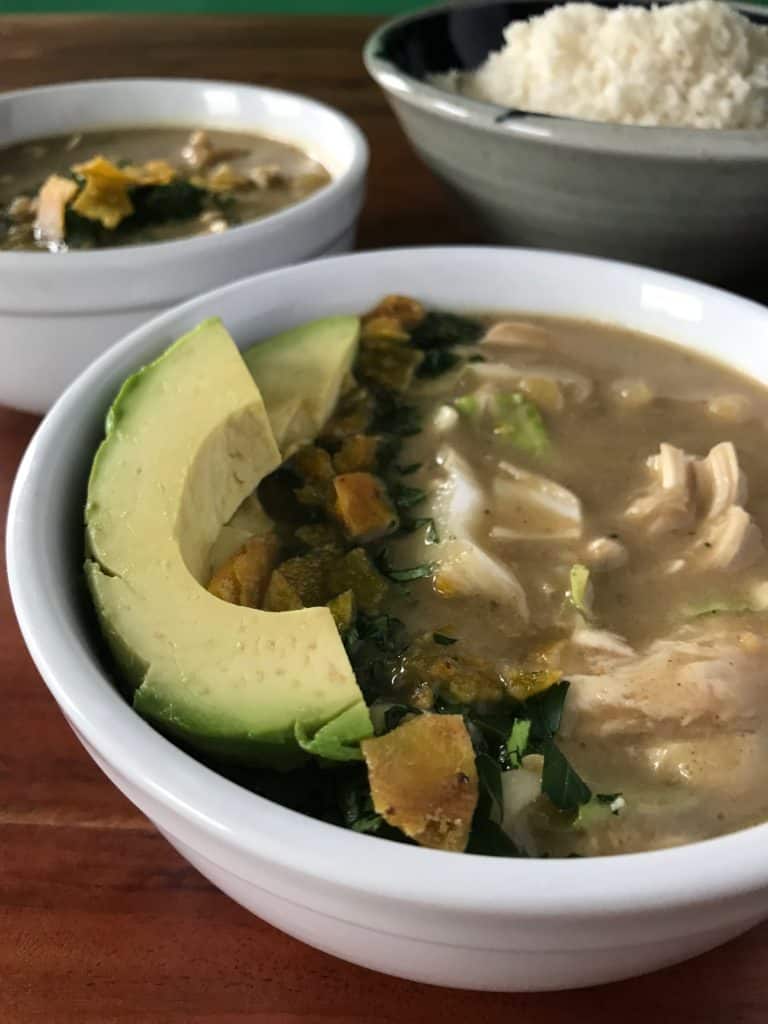 Instant Pot Creamy White Chicken Chili in white bowls with a bowl of cauliflower rice