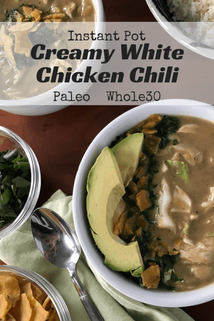 Instant Pot Creamy White Chicken Chili in white bowls surrounded by bowls of garnishes