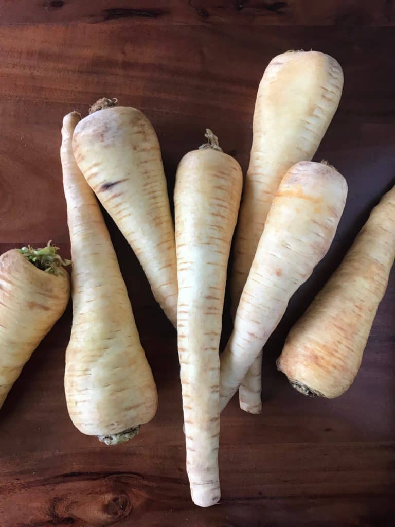 4 bowls of parsnips on a wooden table: parsnip rice, mashed parsnips, parsnip noodles and roasted parsnips