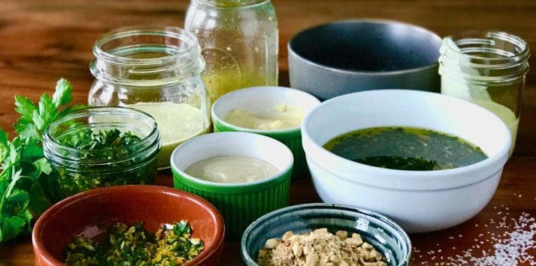 10 flavor boosters you can make while dinner is cooking in various bowls and jars on a wooden table