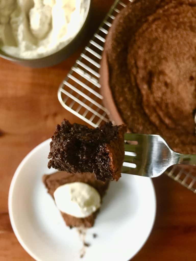 Flourless Chocolate Espresso Cake with Kahlua Whipped Cream on a white plate on a wooden table