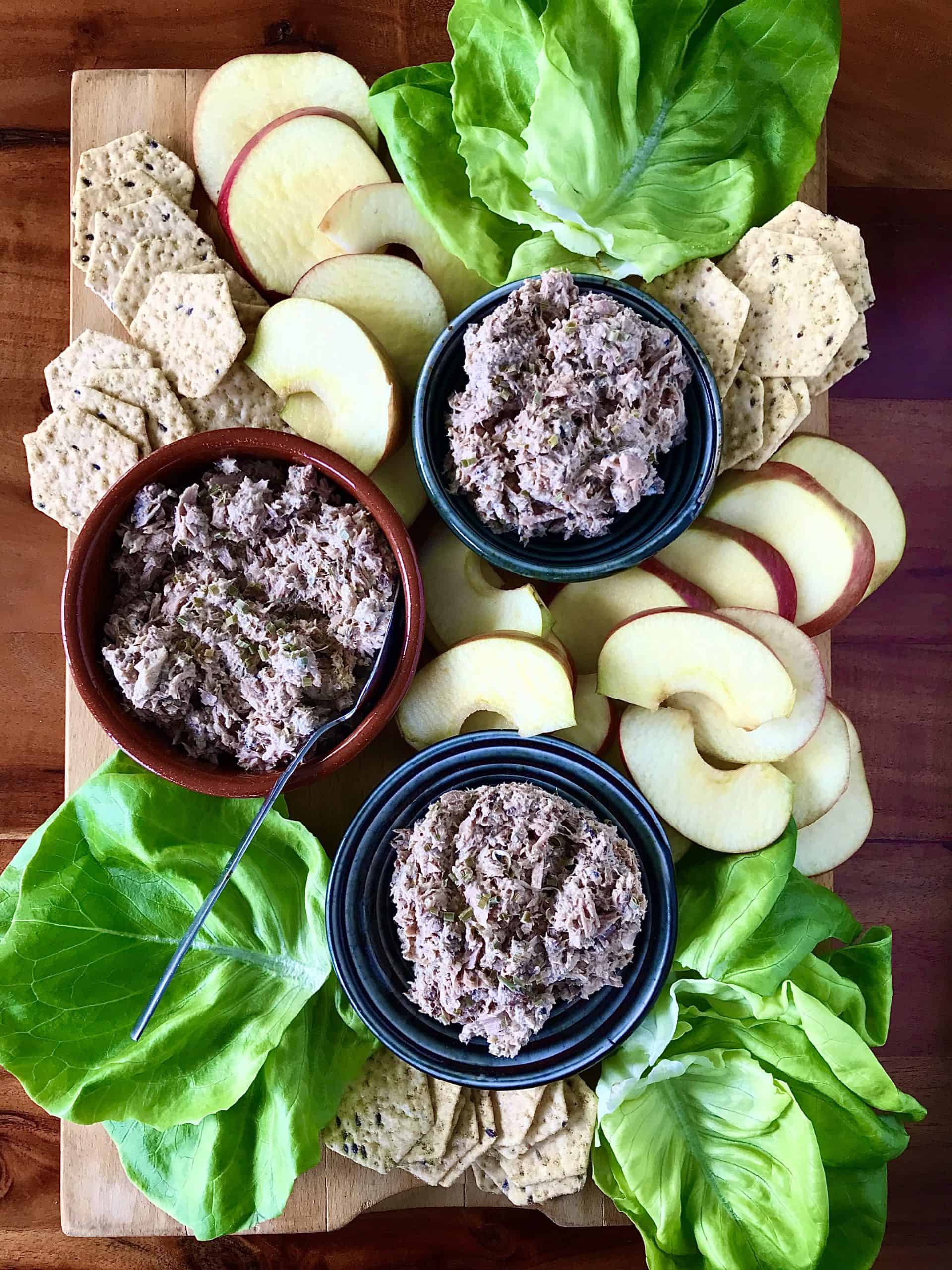 Tuna Sardine Salad on a wooden board with lettuce wraps, apple slices and crackers