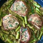 creamy mustard pork chops with asparagus in a nonstick skillet on a wooden table