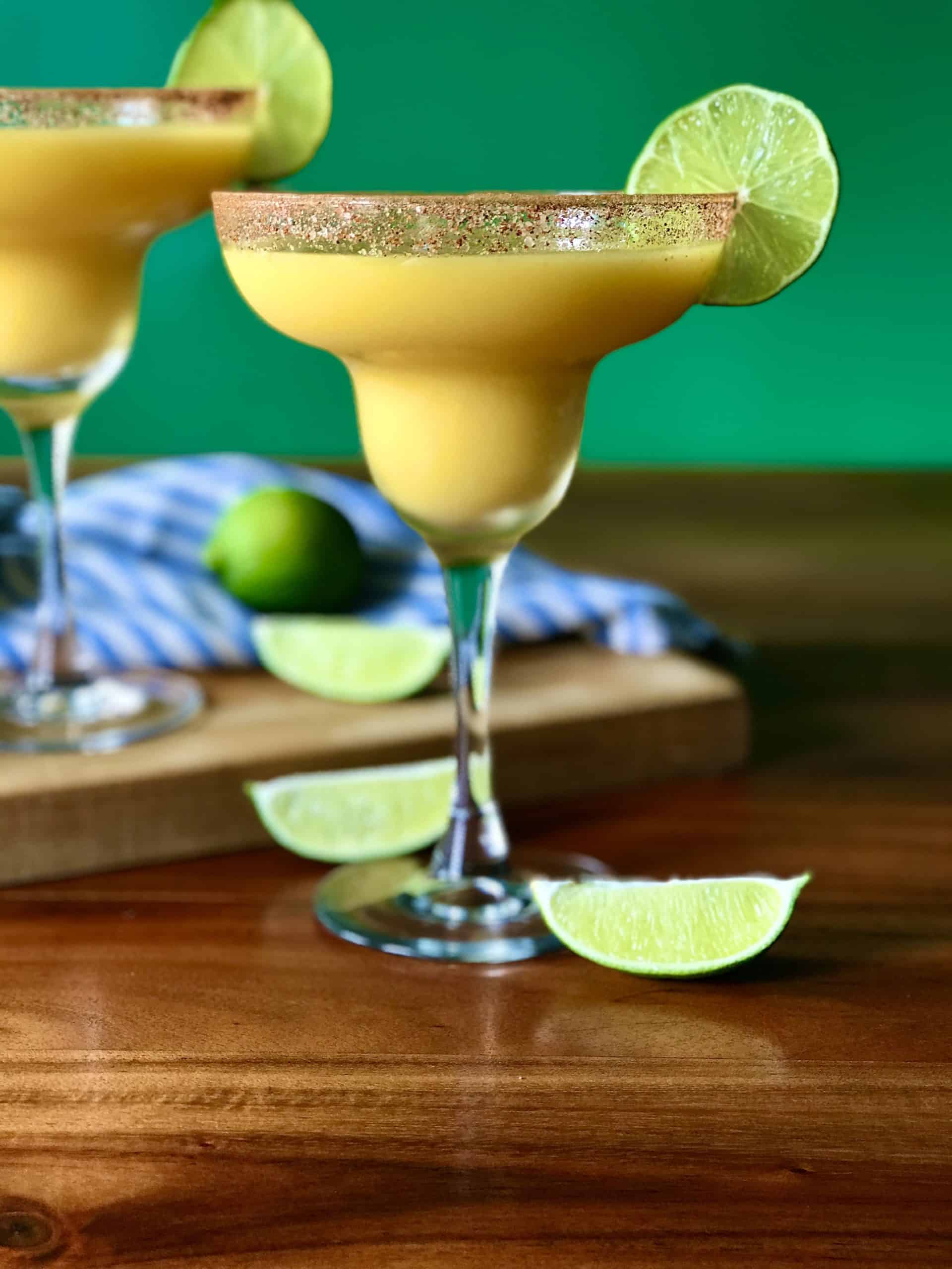 a margarita glass filled with a frozen margarita made with mango, tequila and lime juice