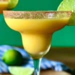 A closeup of a frozen margarita using frozen mango chunks, tequila and lime juice