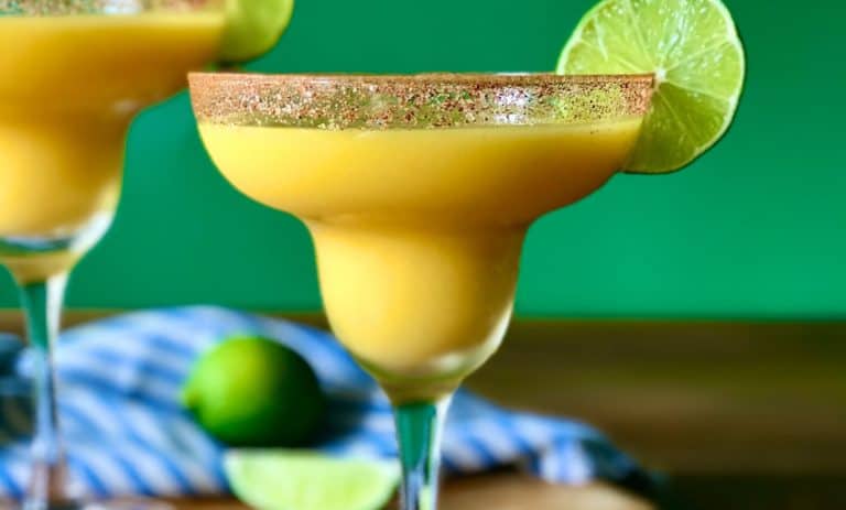 A closeup of a frozen margarita using frozen mango chunks, tequila and lime juice