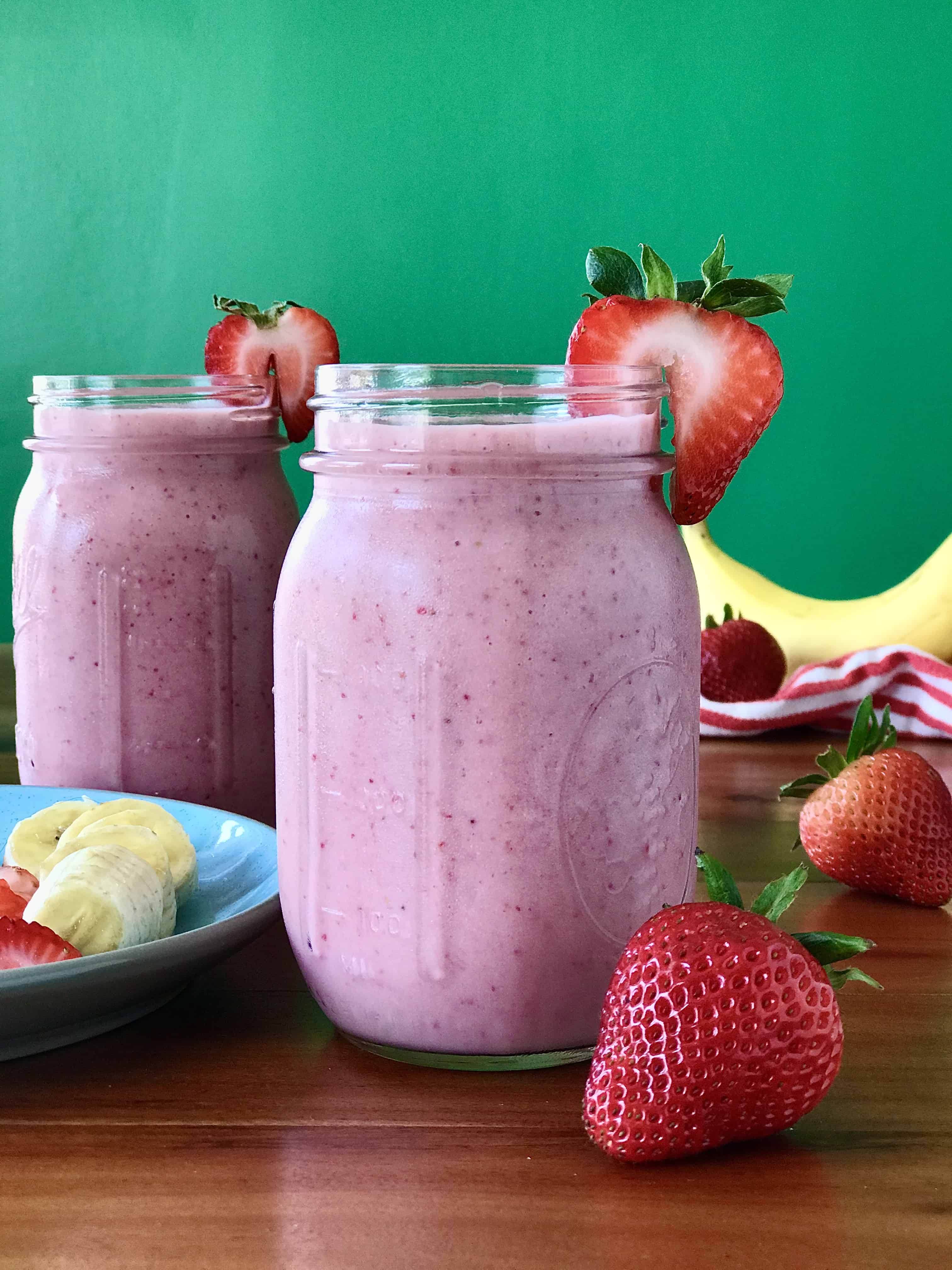 banana smoothie made with strawberries, yogurt and milk in a glass mason jar