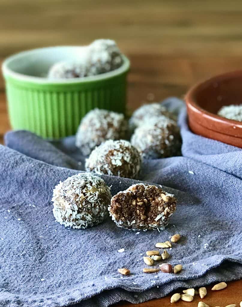 easy gluten-free energy bites on a blue towel and in a small green bowl and brown bowl