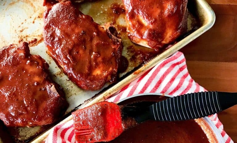 oven baked pork chops with bbq sauce on a baking sheet