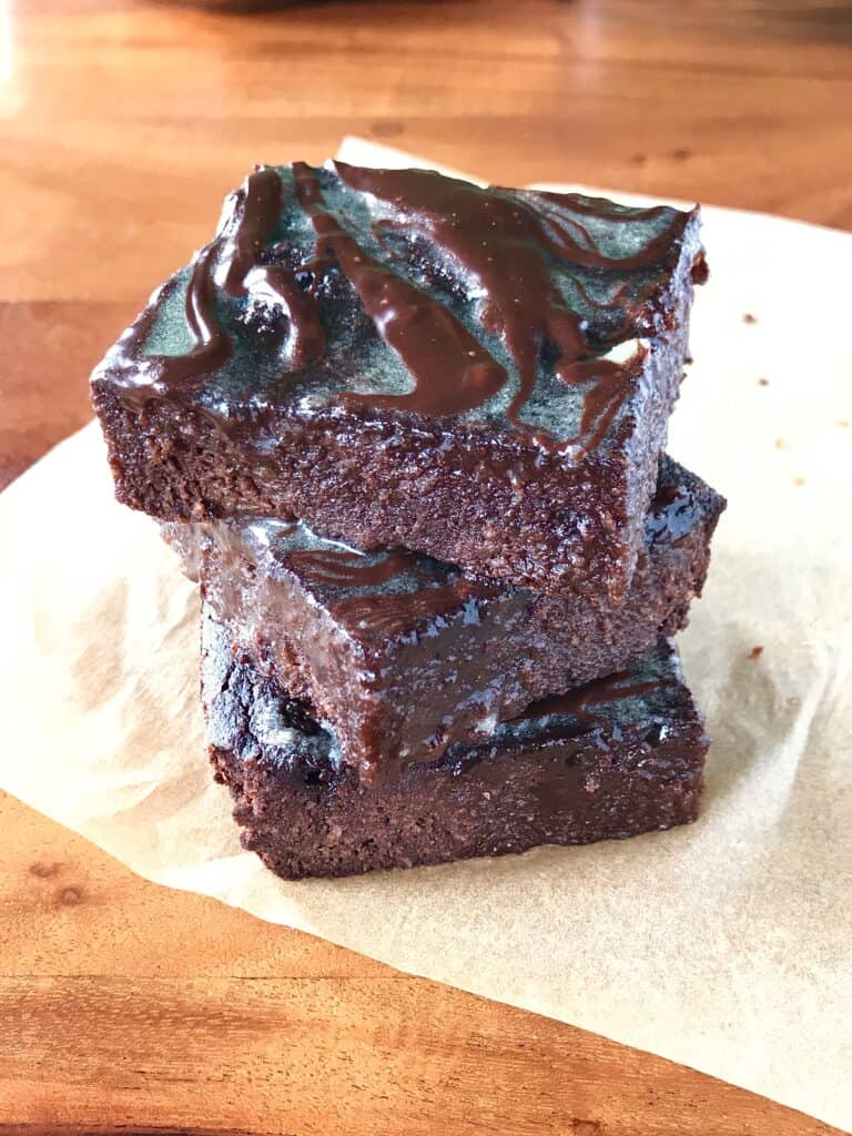 date-sweetened brownies stacked on top of each other on parchment paper