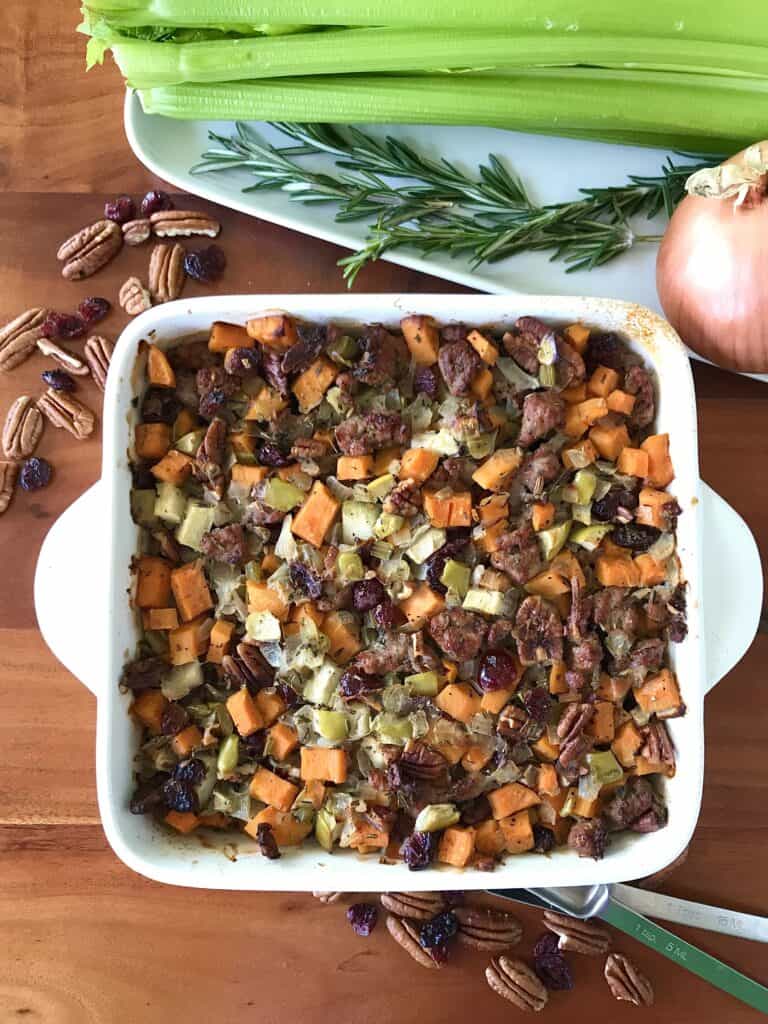 grain-free stuffing with sausage, sweet potato, apple, nuts and herbs in a white baking dish