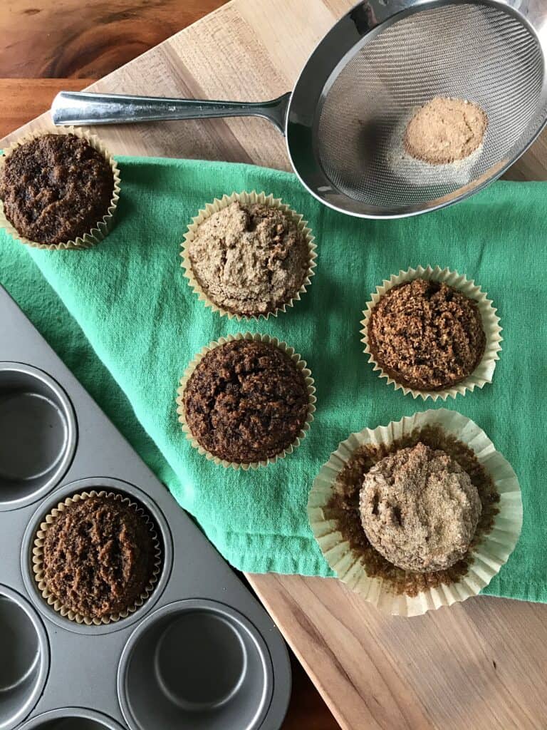 healthy gingerbread muffins on a green towel and in a muffin pan