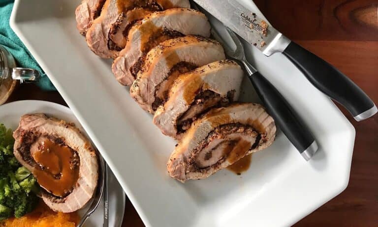 a pork loin recipe with the pork sliced on a white platter and a dinner plate