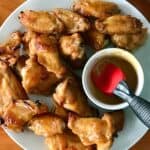 paleo chicken wings on a white platter with a bowl of honey mustard sauce
