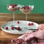an easy no bake ricotta dessert recipe with chocolate piled into coupe glasses and topped with raspberries