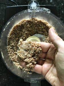 almonds and dates ground into a crust in a food processor for a paleo cheesecake
