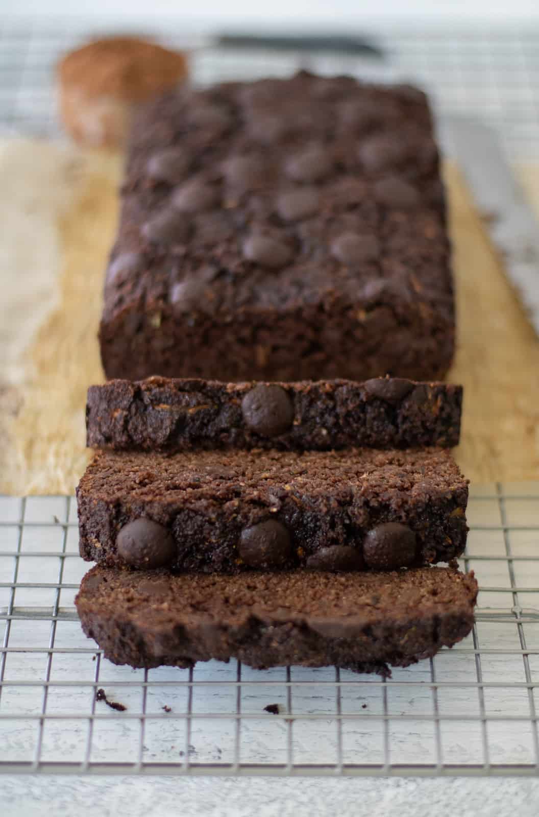 gluten-free zucchini bread made with cocoa powder sliced on a cooling rack