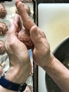 rolling a turkey meatball mixture between two hands
