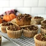 gluten-free pumpkin muffins in their brown muffin cups on a wire cooling rack