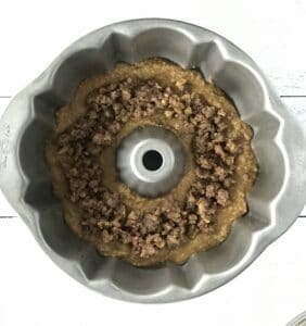 a cake batter with a maple walnut filling in a metal bundt cake pan