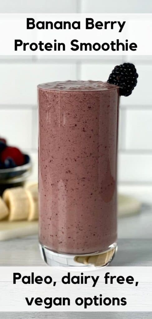 Banana Berry Protein Smoothie in a tall glass garnished with a black berry, in front of a bowl of berries and a sliced banana