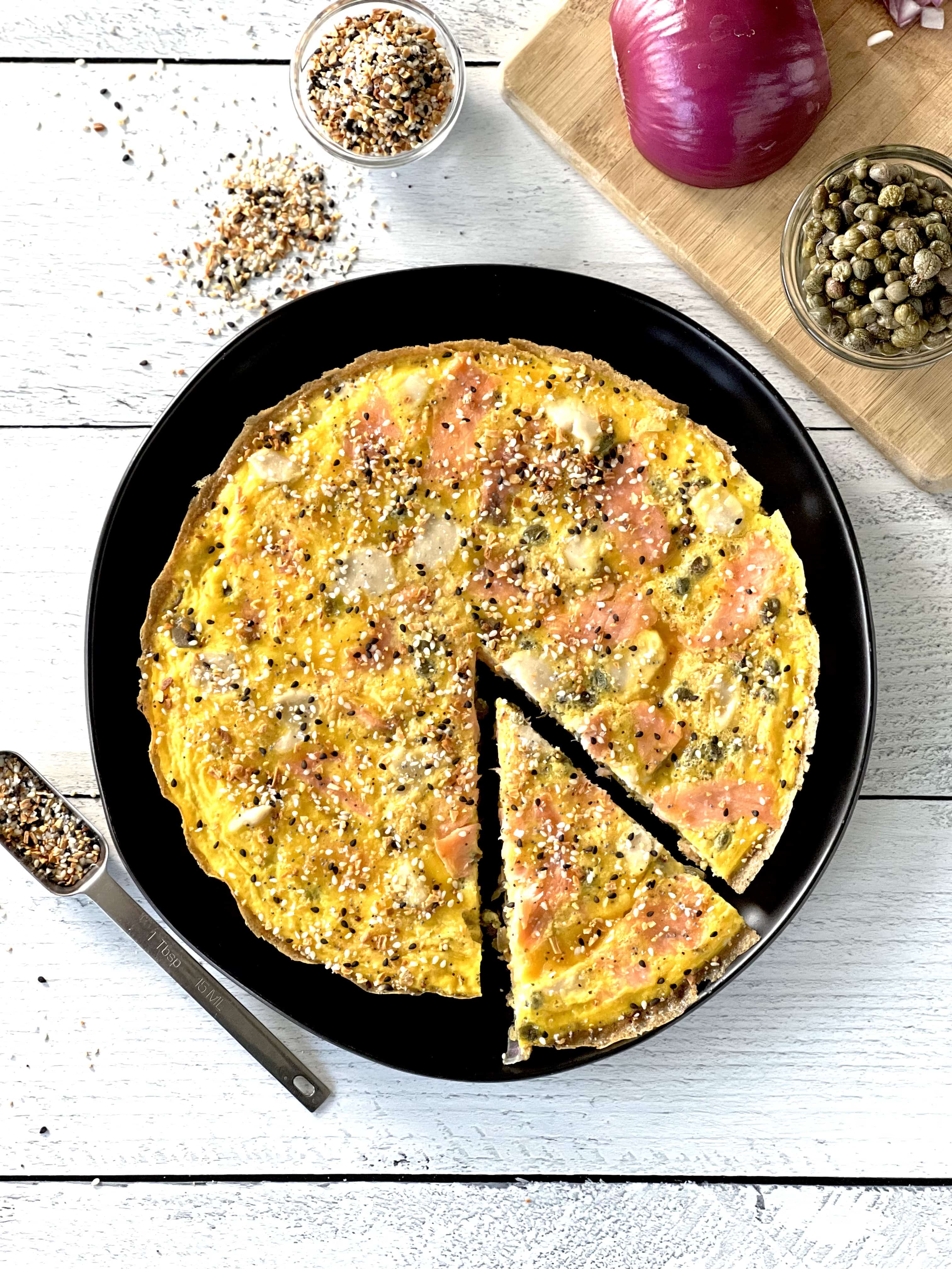 an easy frittata on a black plate with one slice slightly pulled away