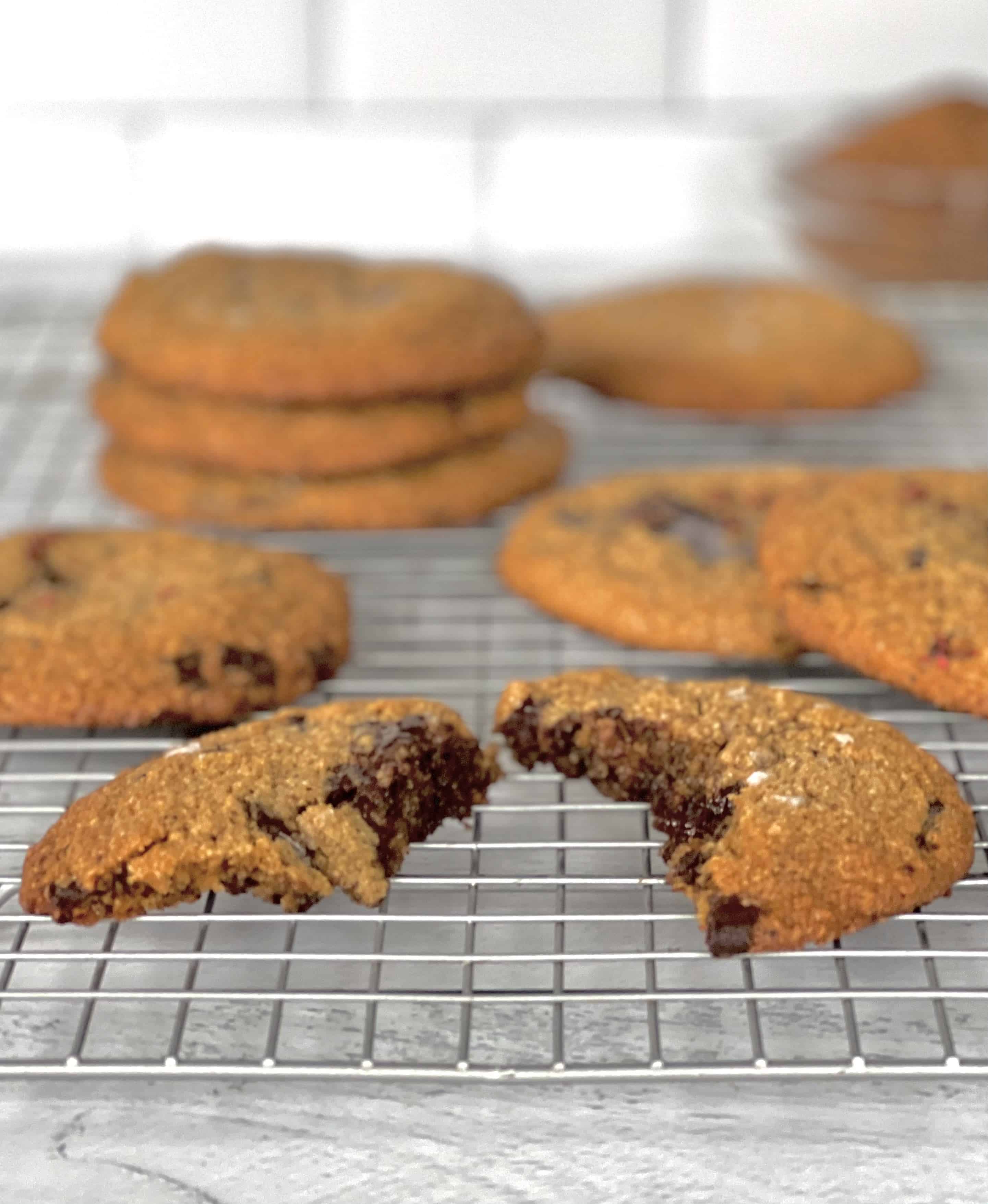 Gluten-Free Chocolate Chunk Cookies on a cooling rack on a white wooden table