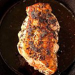 paleo turkey breast roasted in a cast iron skillet on a white wooden table