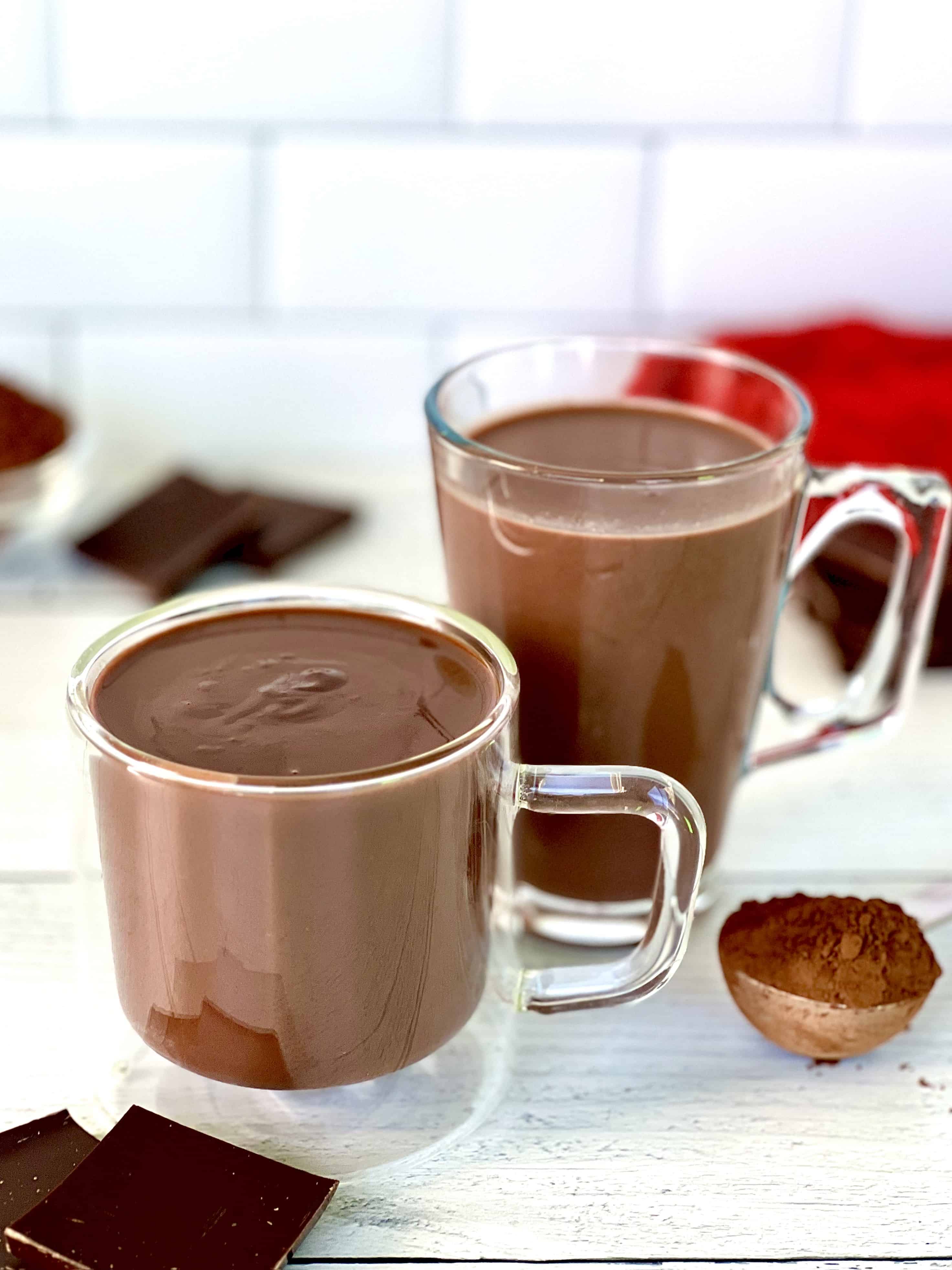 Sipping chocolate in a glass mug next to hot cocoa in a glass mug