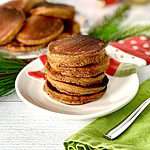 Grain-free pancakes made with ginger and molasses stacked on a snowman plate
