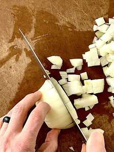 slicing half an onion on a cutting board