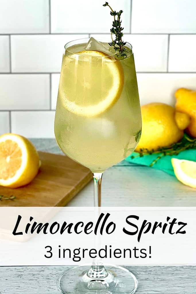Limoncello Spritz in a wine glass with ice cubes, a lemon slice and a sprig of thyme.