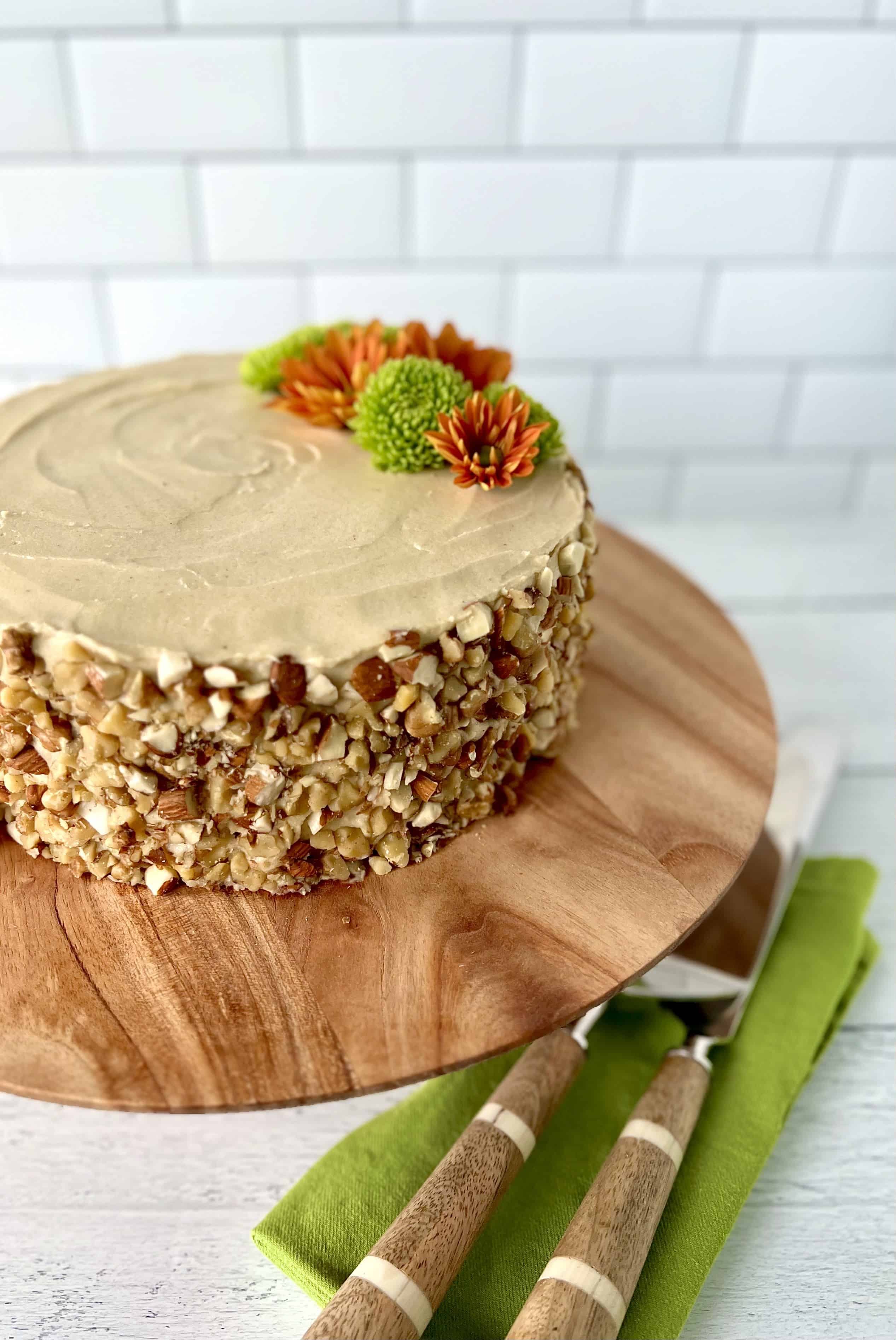 Healthy carrot cake on a wooden cake stand.