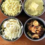 Bowls of roasted parsnips, mashed parsnips, parsnip noodles and parsnip rice on a wooden table.