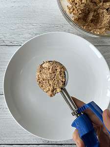 Scooping salmon cake mixture with an ice cream scoop.