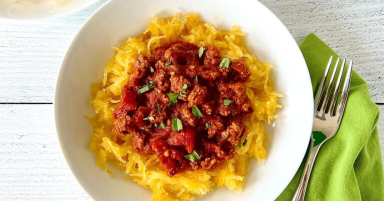Spaghetti squash topped with a ground beef sauce in a white bowl.