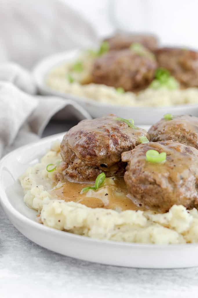 Swedish meatballs covered in gravy on a bed of mashed potatoes.