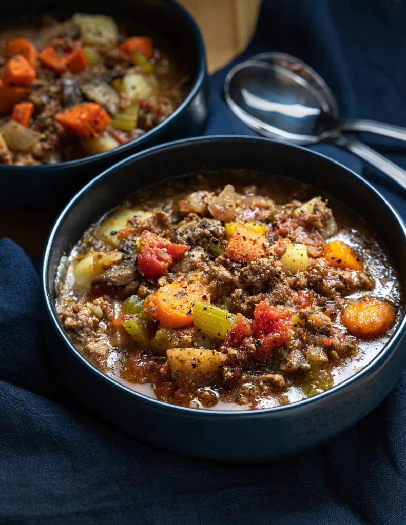 Hamburger soup in black bowls.