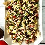 Gluten-free nachos without cheese on a long white platter.