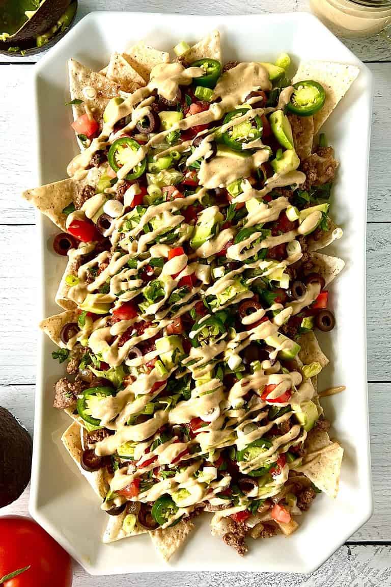 Gluten-free nachos without cheese on a long white platter.