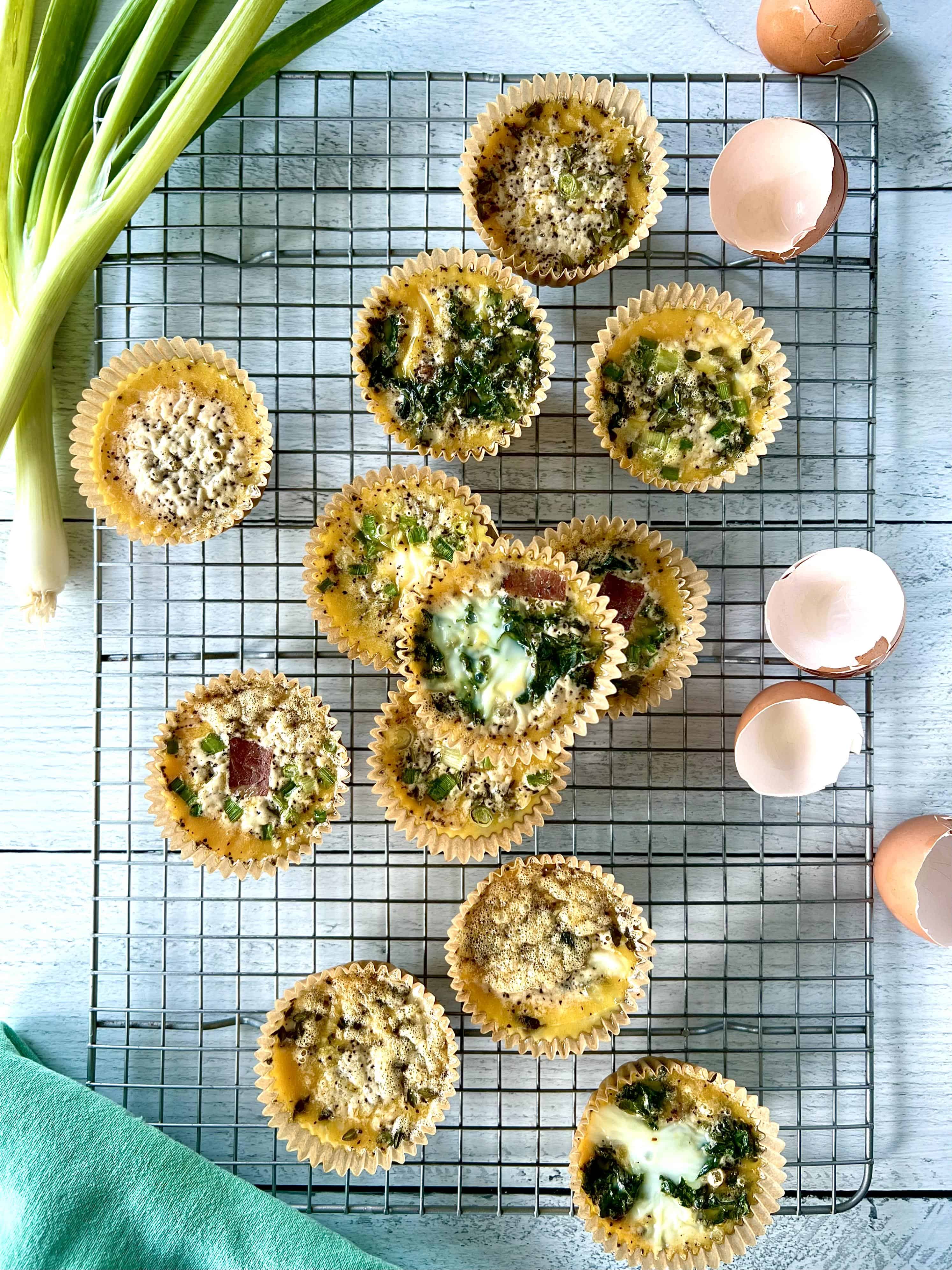 Healthy egg muffins in muffin liners on a cooling rack.