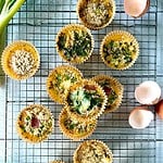 Healthy Whole30 egg muffins in muffin liners on a cooling rack.