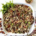 Paleo Thanksgiving stuffing in a large square white bowl with a large serving spoon.