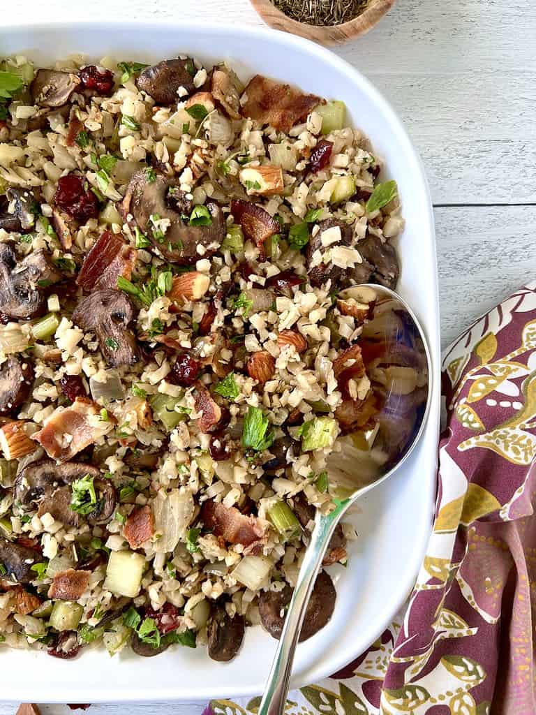 Whole30 stuffing in a large square white bowl with a large serving spoon.
