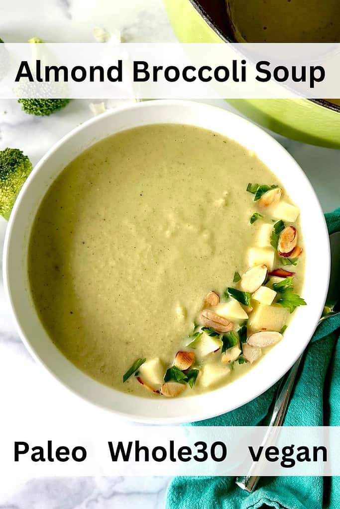 Almond Broccoli Soup in a bowl topped with parsley, sliced almonds and diced apples.