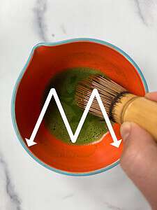 Whisking matcha in a bowl.