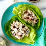 Cranberry and Pecan Chicken Salad in lettuce cups on a plate.
