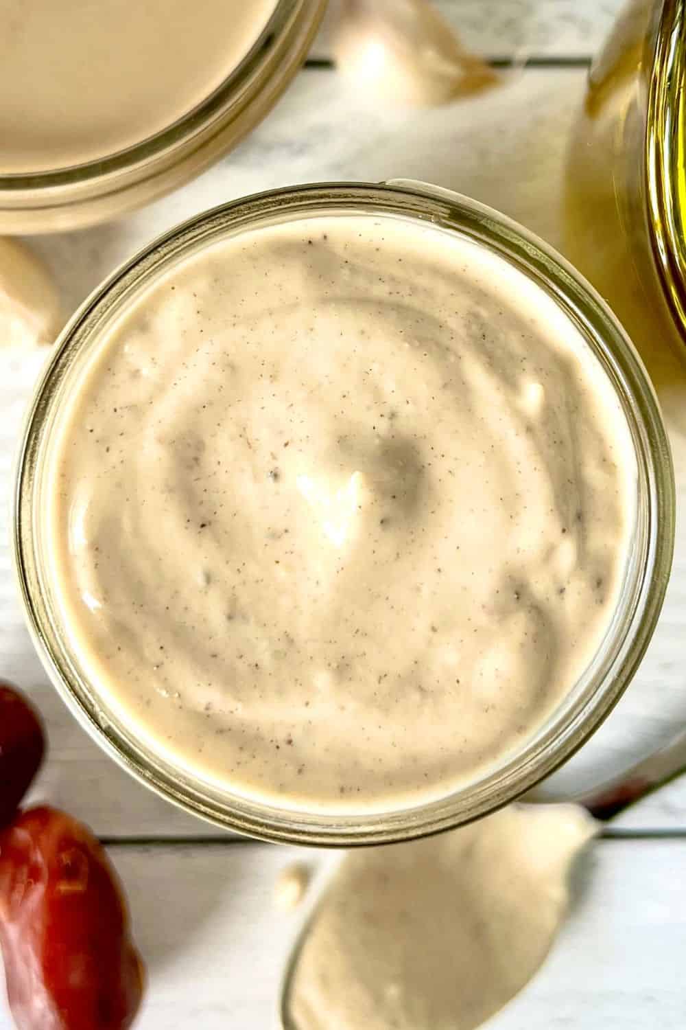 Tahini dressing with dates in a glass mason jar.