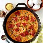 A Whole30 frittata topped with pepperoni in a cast iron skillet.